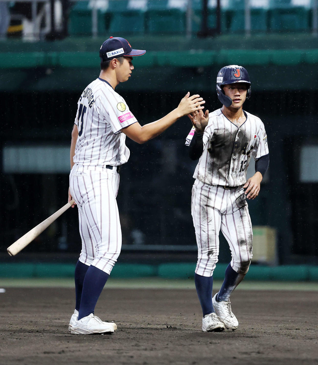 南アフリカ対日本　1回裏日本1死三塁、高畑の犠飛で岡部（右）が生還し下重とタッチ（撮影・鈴木正人）