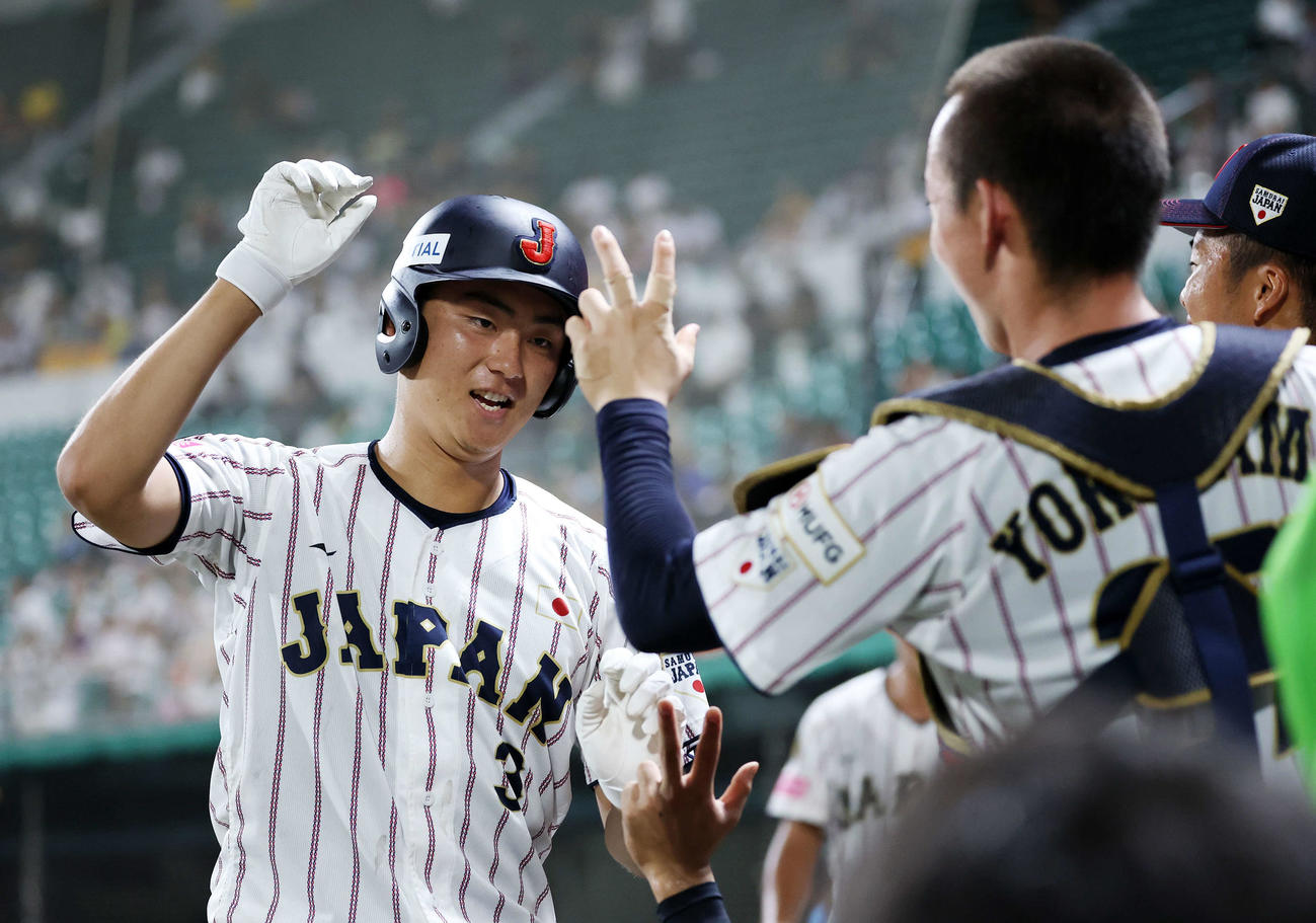 南アフリカ対日本　3回裏日本1死一塁、今岡は左越え2点本塁打を放ちベンチ前でタッチ（撮影・鈴木正人）