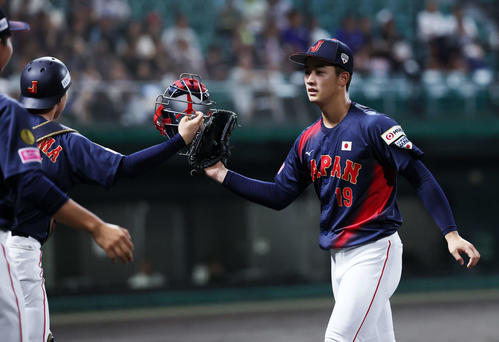 日本対プエルトリコ 1回裏、プエルトリコの攻撃を抑えタッチする日本・横山(左)と奥村頼(撮影・鈴木正人)