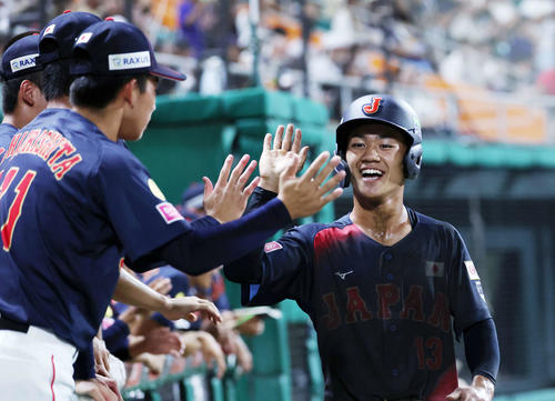 日本対アメリカ 8回表日本無死二塁、藤森の打球が失策になり岡部(右)が生還しベンチ前で笑顔を見せる(撮影・鈴木正人)