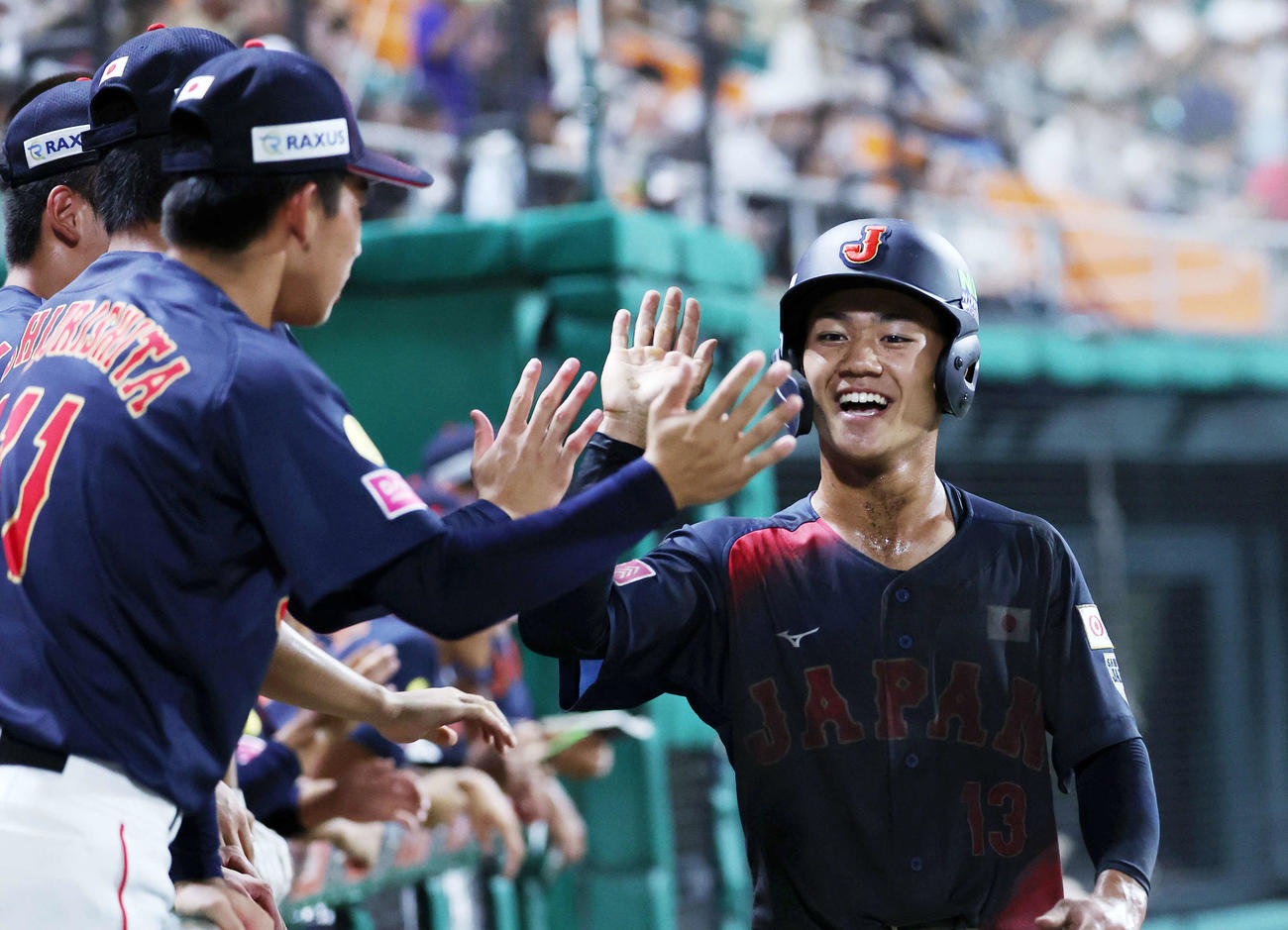 日本対アメリカ　8回表日本無死二塁、藤森の打球が失策になり岡部（右）が生還しベンチ前で笑顔を見せる（撮影・鈴木正人）