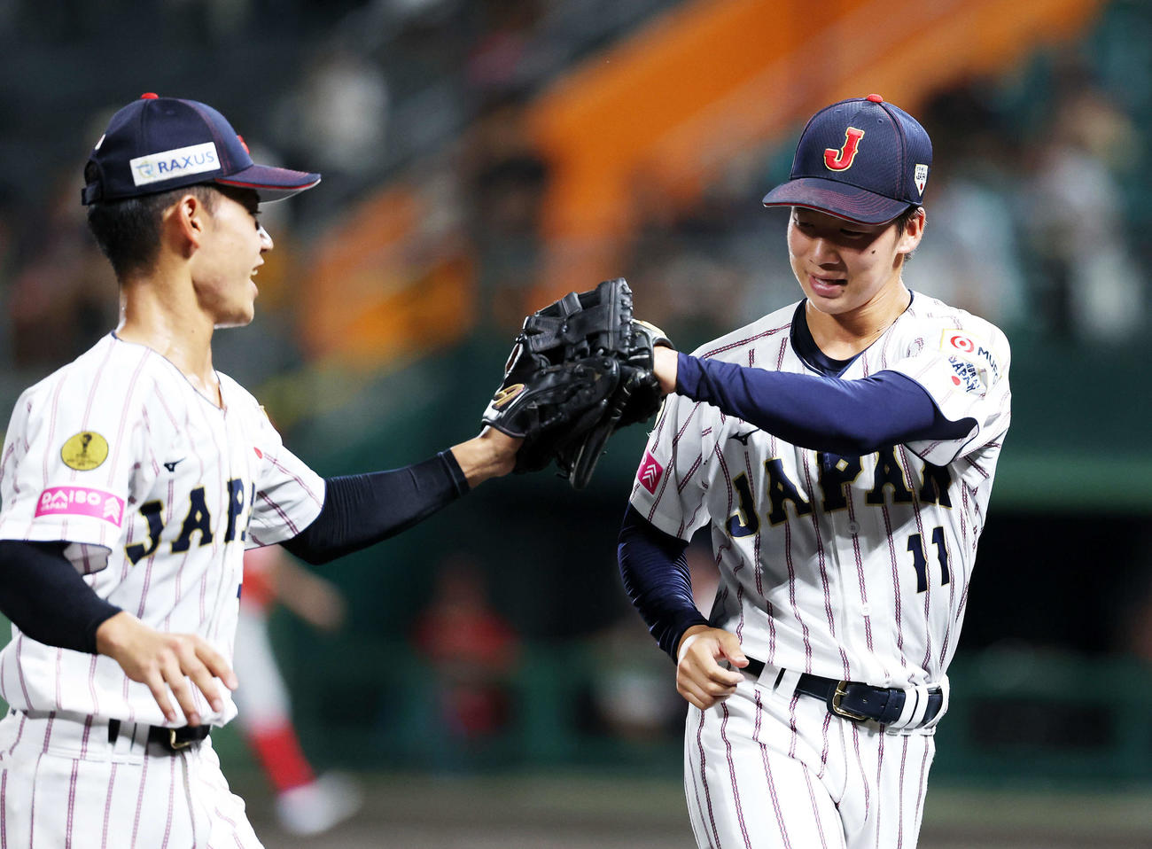 パナマ対日本　4回表、パナマの攻撃を抑えグラブタッチする日本・岡部（左）と森下（撮影・鈴木正人）