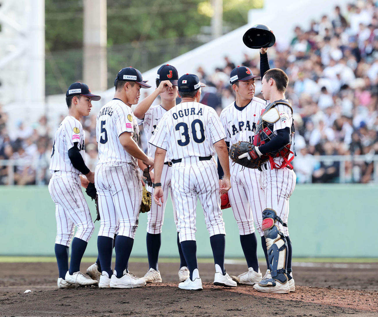 米国対日本　5回表、マウンドに集まる日本・小倉監督（中央）と選手たち（撮影・鈴木正人）