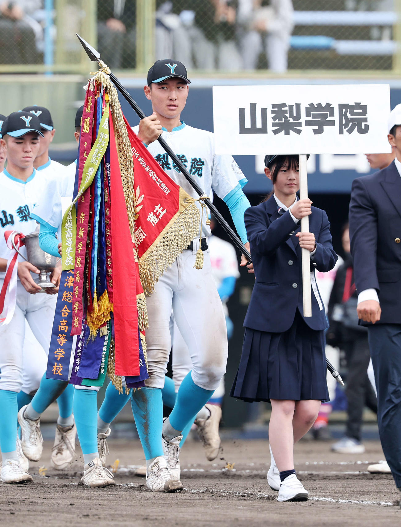 優勝旗を手に行進する山梨学院・菰田（撮影・鈴木正人）