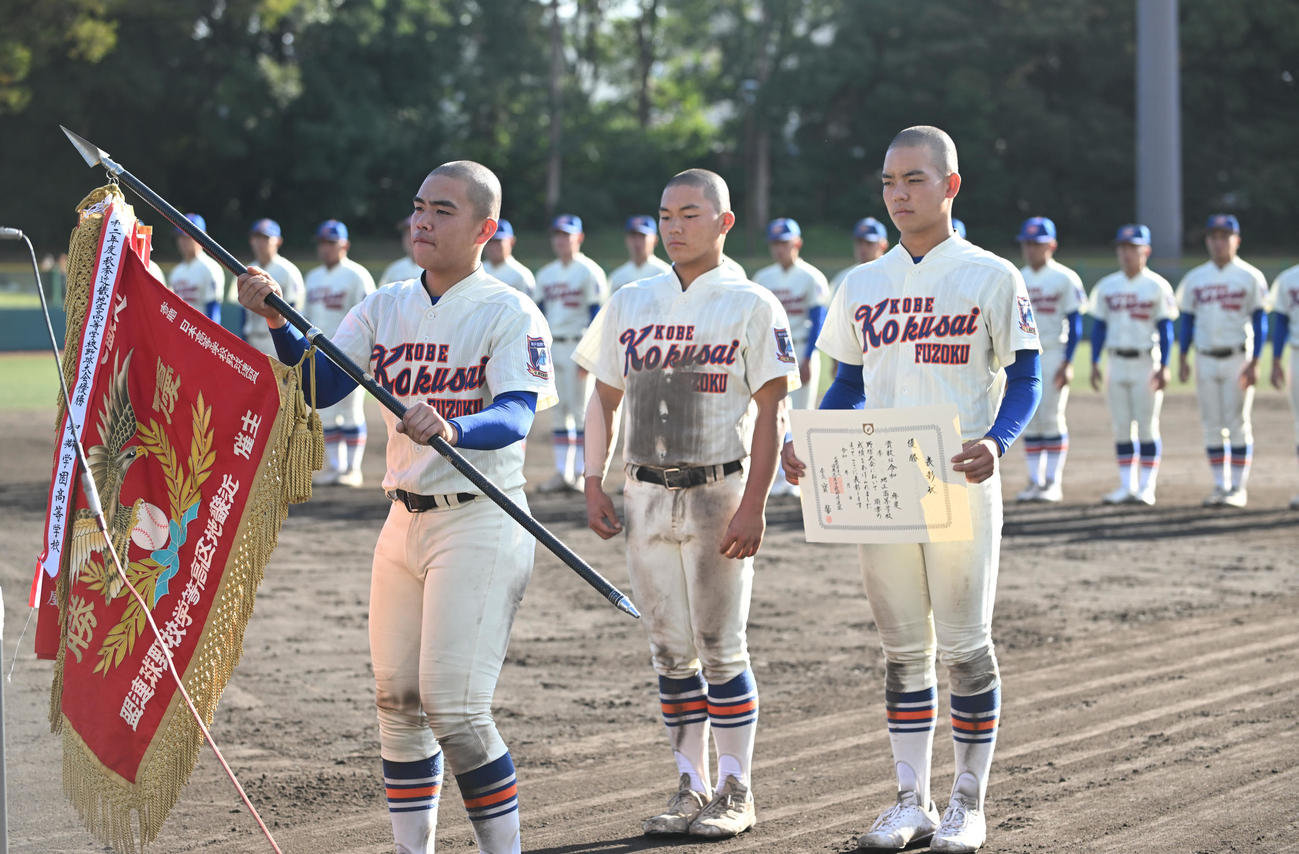 優勝し優勝旗を受け取る神戸国際大付の井本主将（撮影・滝沢美穂子）