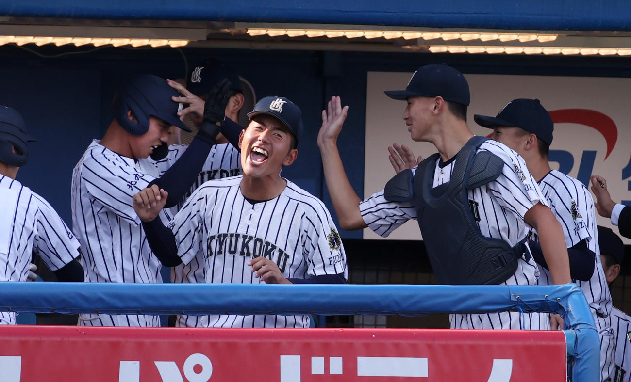 山梨学院対九州国際大付　7回裏九州国際大付無死、牟礼（左端）は中越えに本塁打を放ち、ベンチ内でナインの祝福を受ける（撮影・柴田隆二）