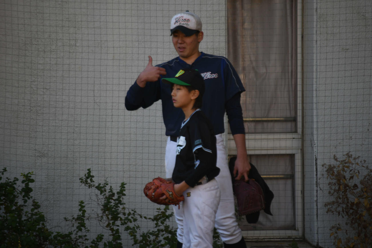 若羽クラブの児童に投げ方を教える広尾・古荘（撮影・平山連）