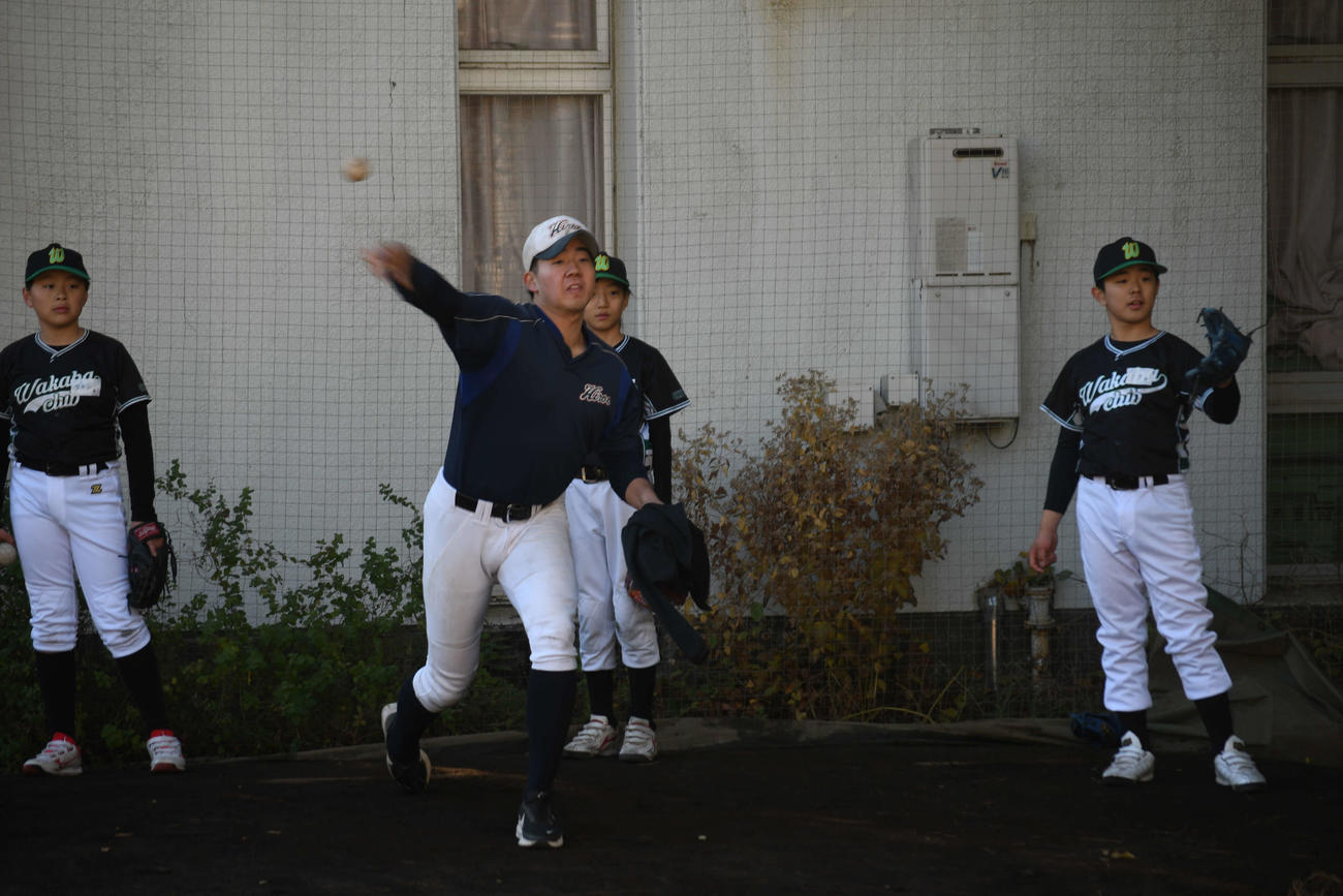 若羽クラブの児童に投げ方を教える広尾・古荘（撮影・平山連）