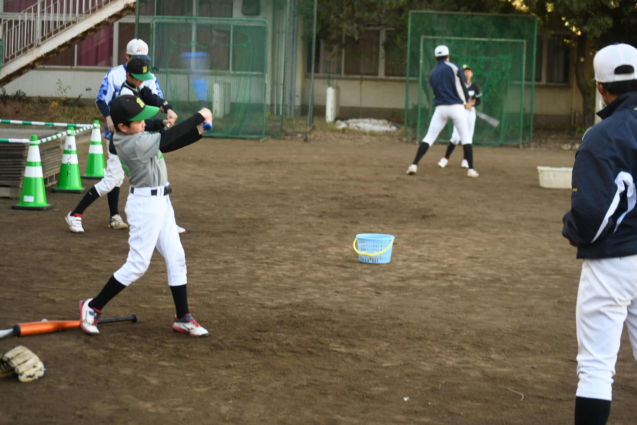 打ち方のコツを若羽クラブの児童に教える広尾の球児（撮影・平山連）