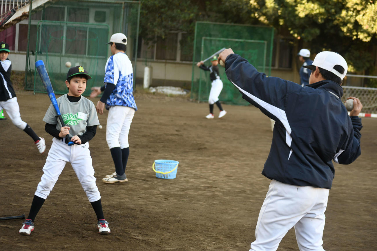 打ち方のコツを若羽クラブの児童に教える広尾の球児（撮影・平山連）
