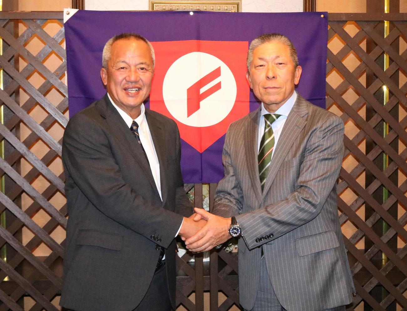 U18代表の岡田龍生新監督（左）と小倉全由前監督が握手を交わす（撮影・林亮佑）