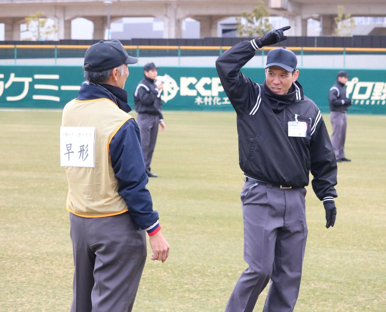 中学野球の審判（左）が日本高野連所属の審判にジェスチャーを教わる（撮影・林亮佑）