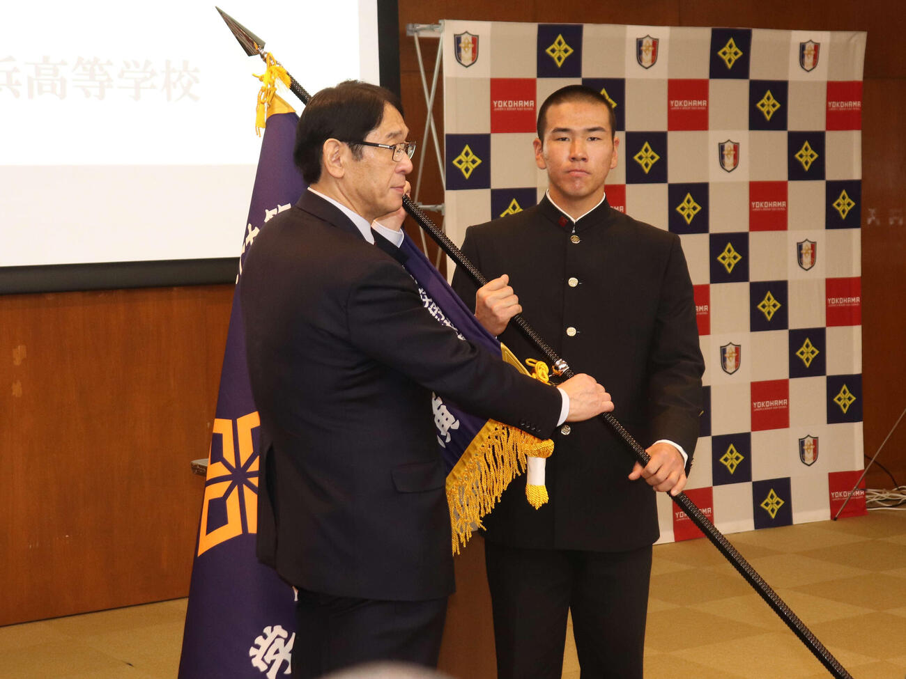 センバツ旗授与式で、横浜高校の葛校長からセンバツ旗を受け取る小野主将（撮影・保坂淑子）