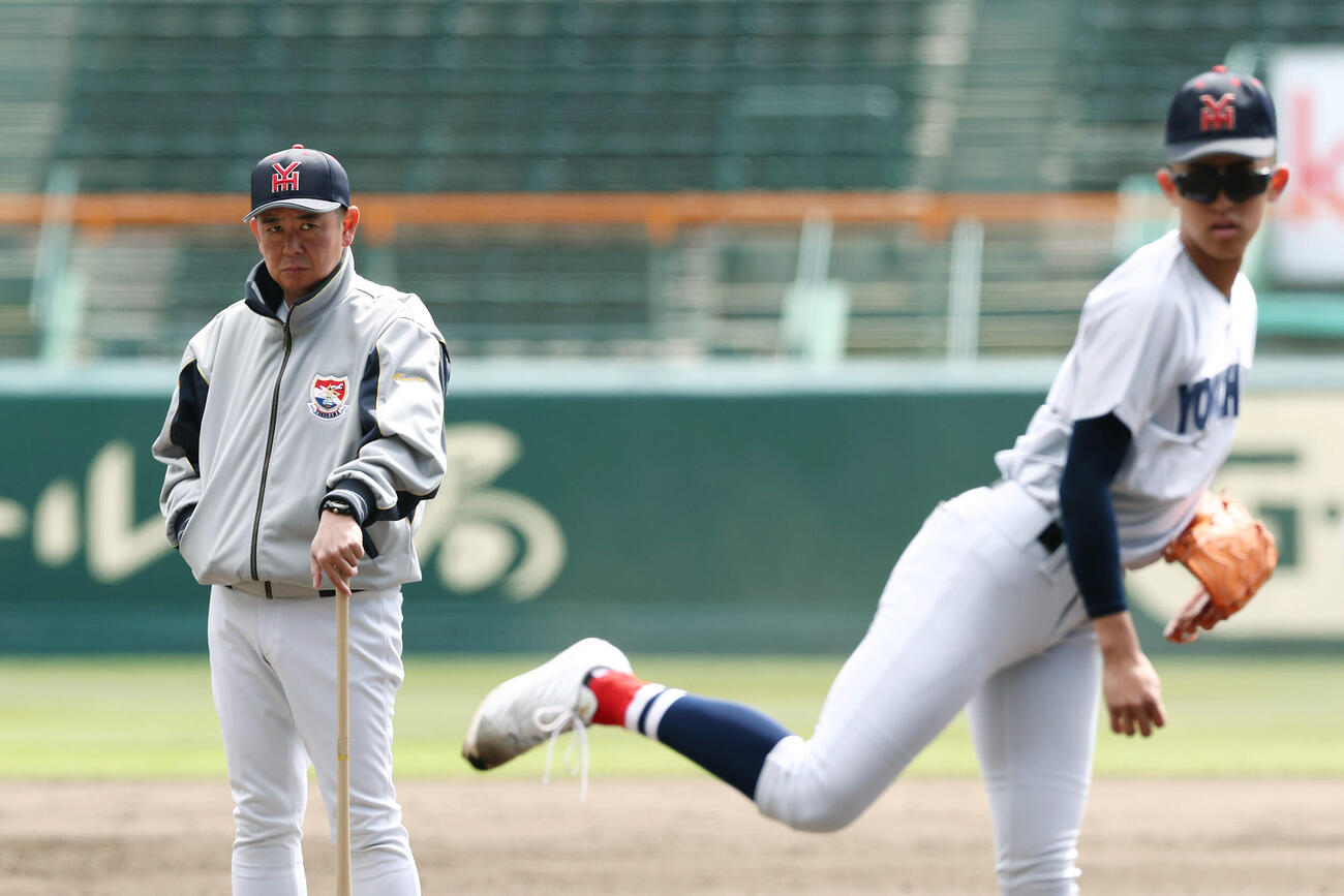 甲子園球場で横浜・織田（右）の投球練習を見守る村田監督（撮影・前田充）