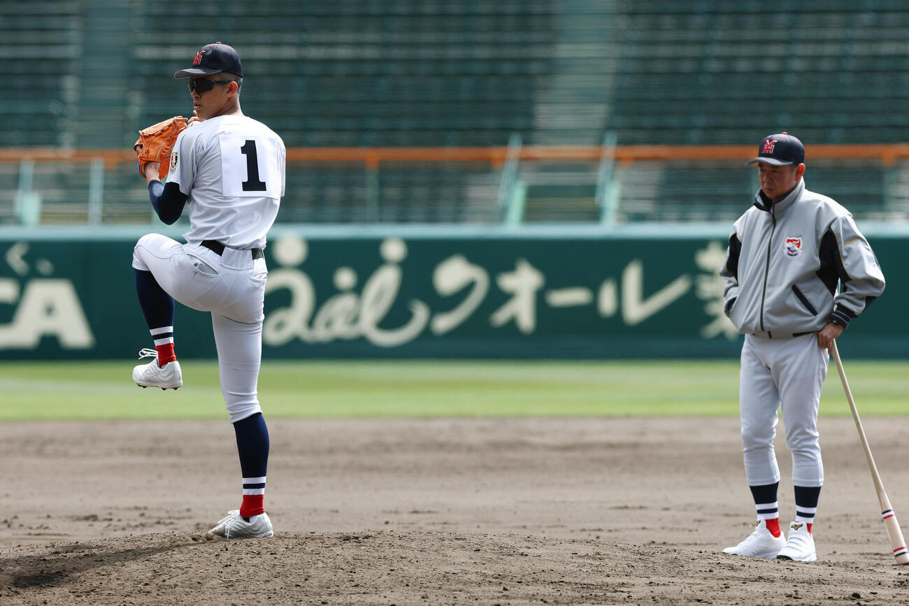 甲子園球場で投球練習を行う横浜・織田。右は見守る村田監督（撮影・前田充）
