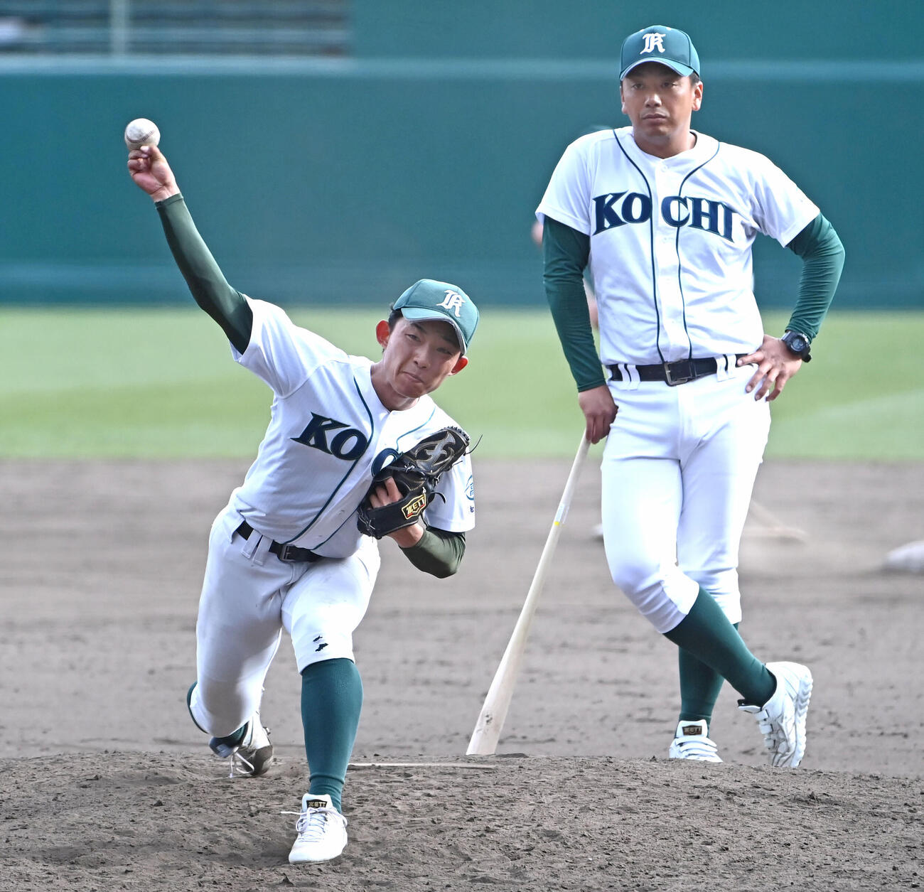高知農・下坂充洋監督（右）が見守る中、投球練習をする山下蒼生（撮影・石井愛子）