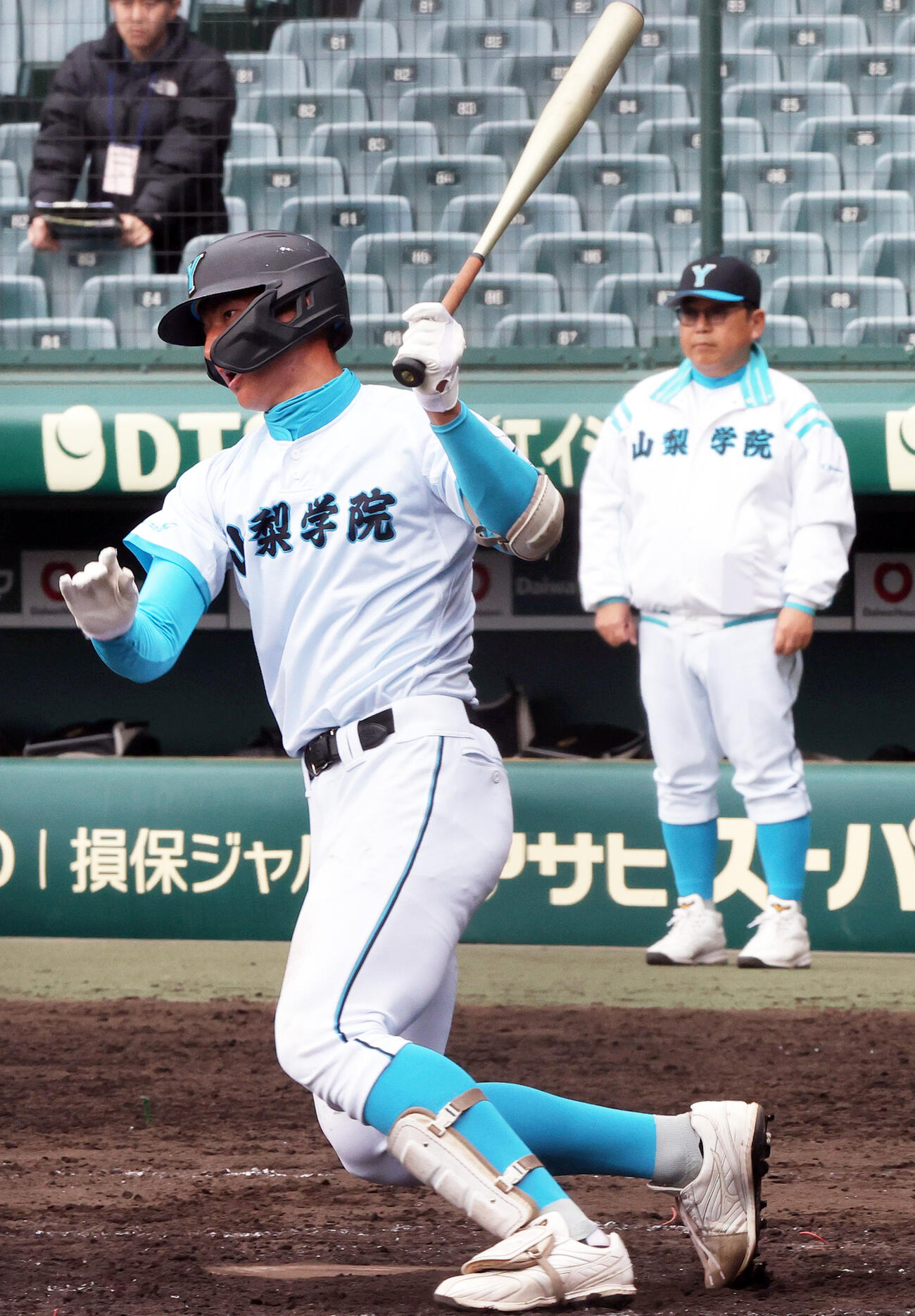 甲子園練習で打撃する山梨学院の菰田。後方右は吉田監督（撮影・上山淳一）