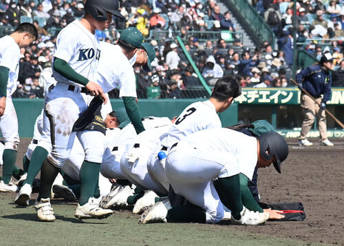 日本文理対高知農　日本文理に負け甲子園の土を集める高知農ナイン（撮影・石井愛子）