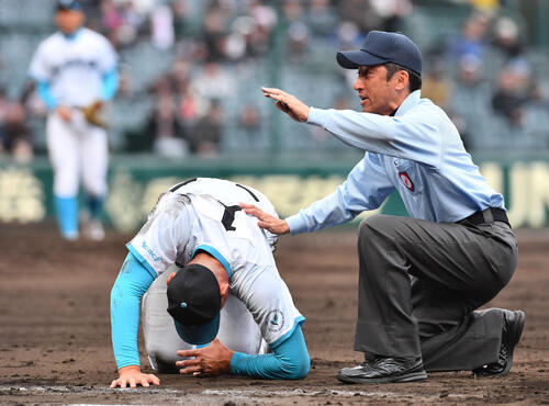 山梨学院対長崎日大　5回裏長崎日大2死一塁、三塁からの悪送球で打者の平野と交錯し左手を痛めた一塁手の山梨学院菰田（撮影・岩下翔太）