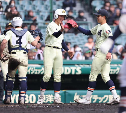 高川学園対英明　完投勝利の英明冨岡（右）はナインとタッチをかわす（撮影・西尾就之）