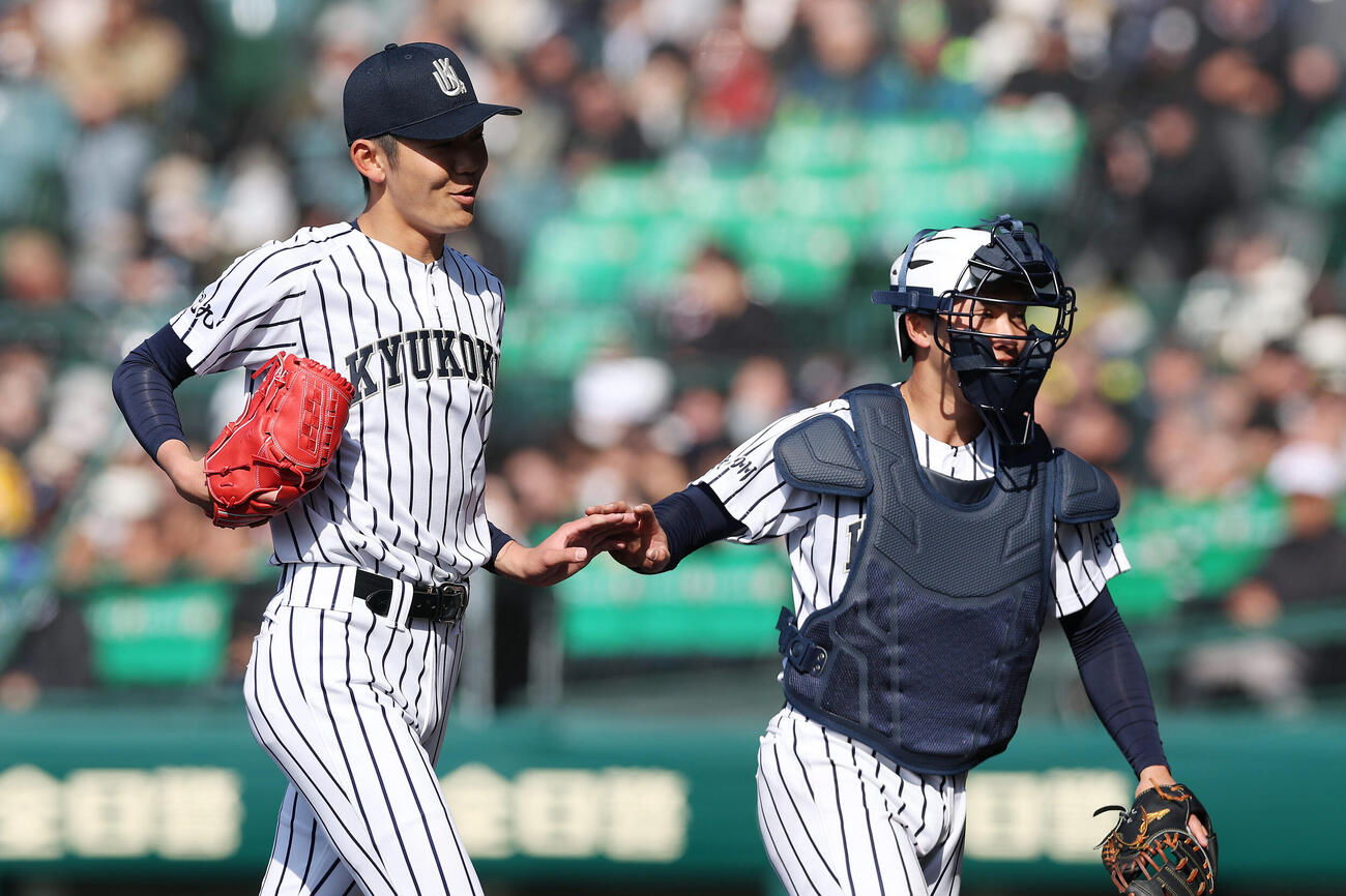 神戸国際大付対九州国際大付　1回表の神戸国際大付打線を抑え、城野（右）とタッチを交わしてベンチへ戻る九州国際大付先発の岩見（撮影・前田充）