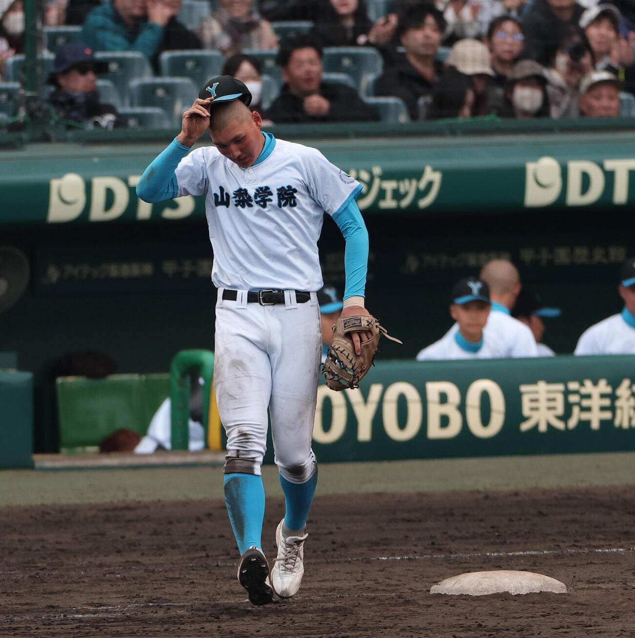 山梨学院対長崎日大　5回裏長崎日大2死一、三塁、治療を終え守備に向かう一塁手菰田（撮影・上山淳一）