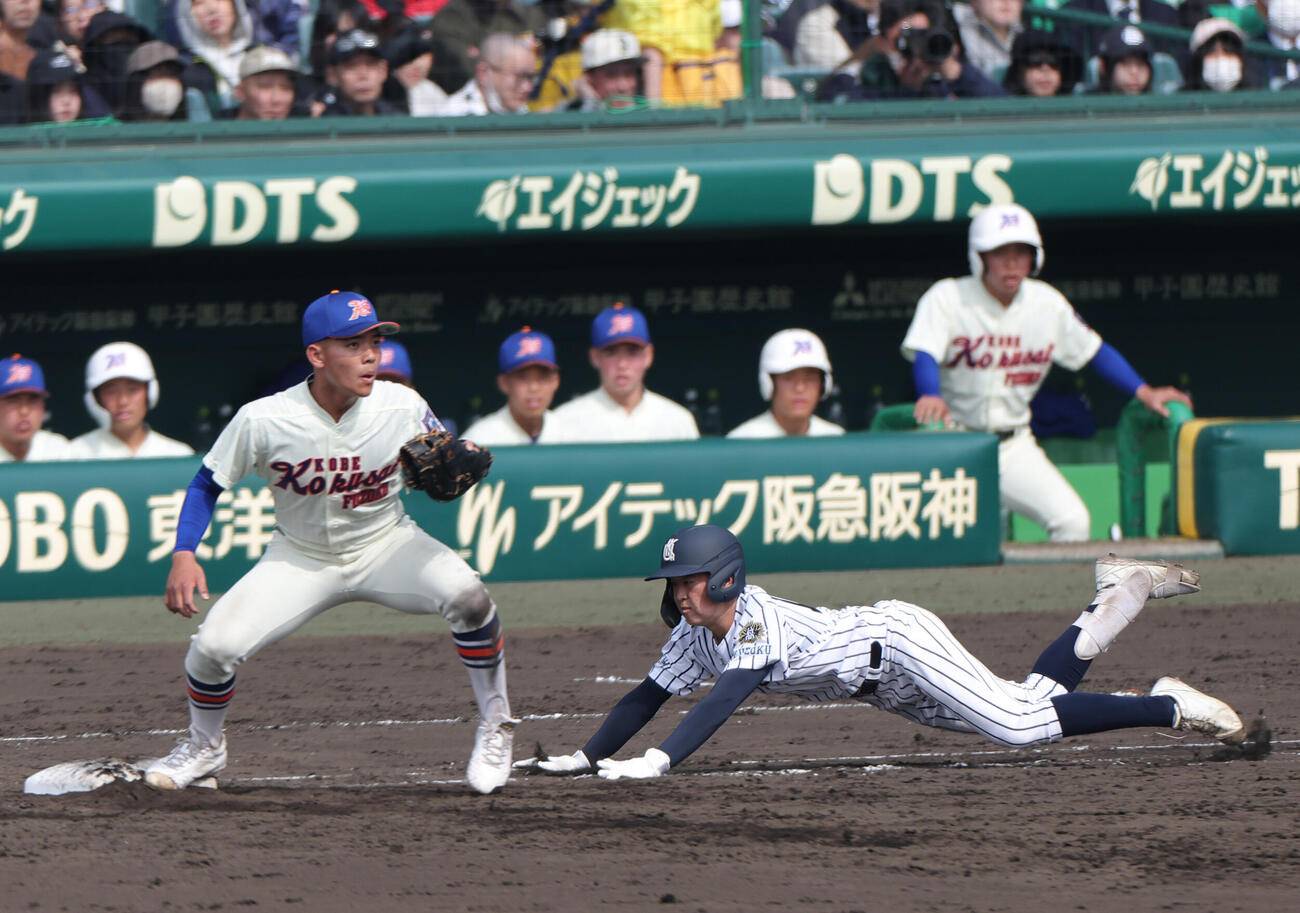 神戸国際大付対九州国際大付　4回裏九州国際大付1死一塁、岡松（右）は三ゴロで一塁ヘッドスライディングし併殺を回避しセーフをもぎ取る。一塁手比嘉（撮影・上山淳一）