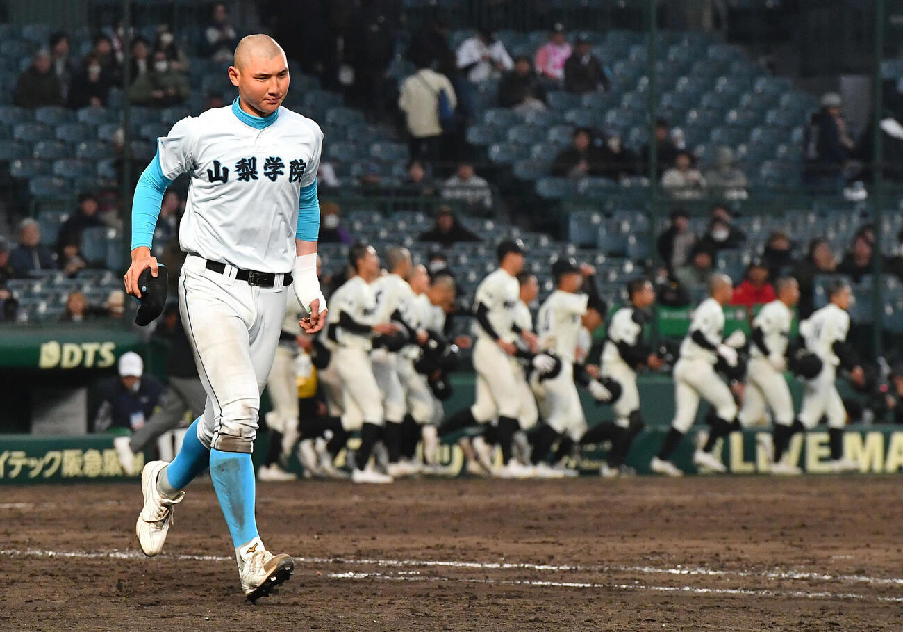 長崎日大に勝利し、アルプススタンドの応援団のもとに走る山梨学院・菰田（2026年3月撮影）
