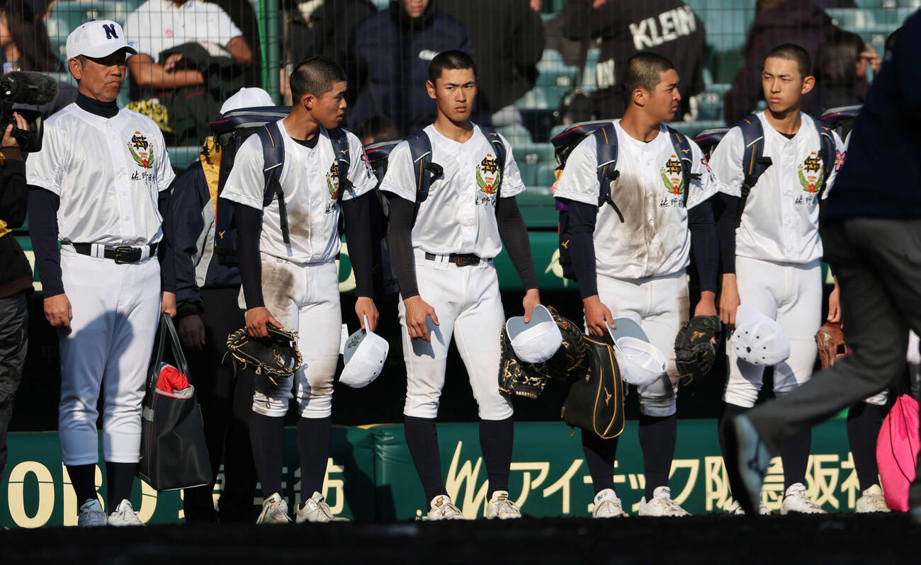 三重対佐野日大　初戦敗退の佐野日大ナインは麦倉監督（左）とともにグラウンドに整列（撮影・西尾就之）