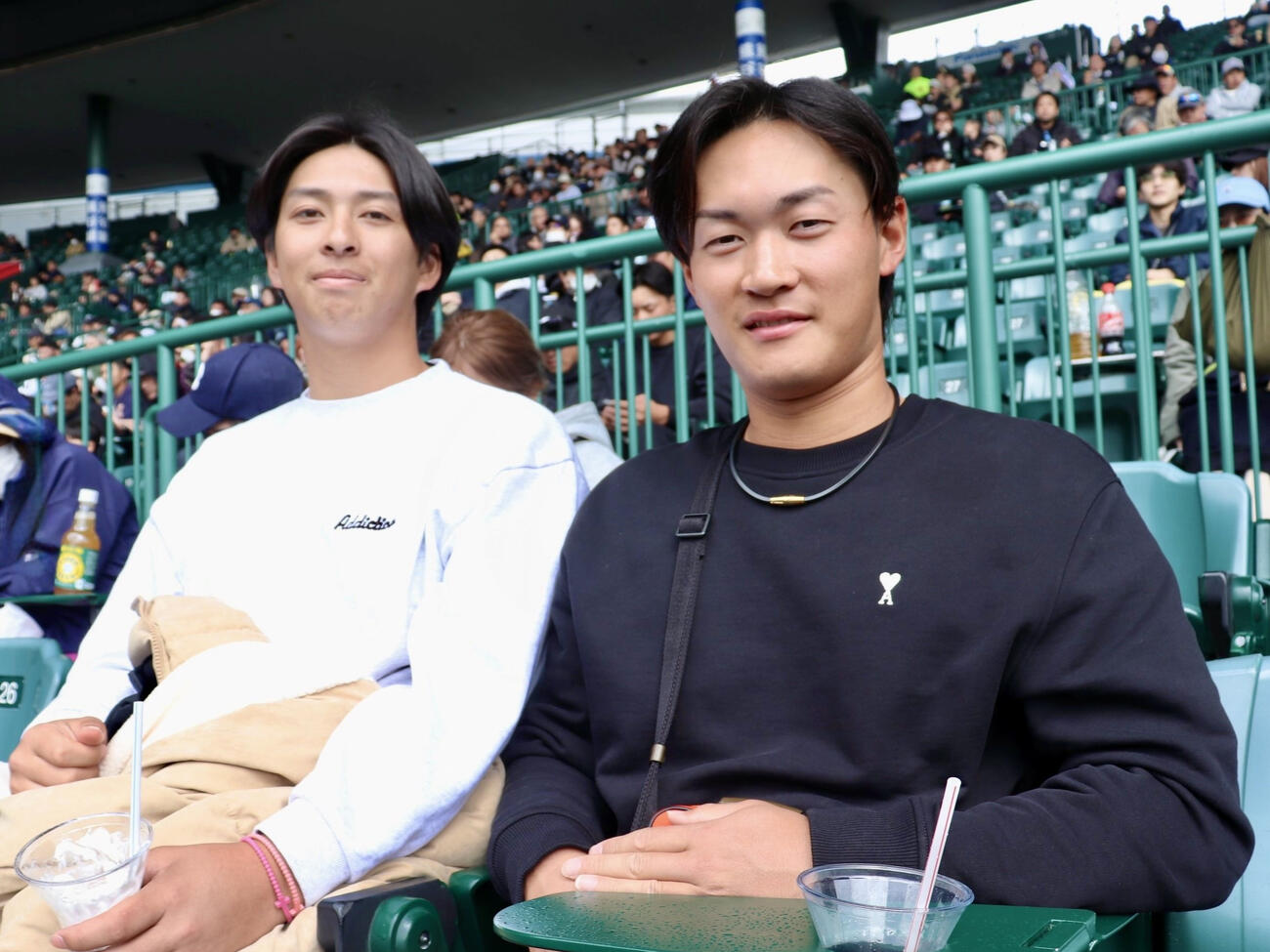 母校英明の初戦に駆けつけたOBのオリックス育成・寿賀弘都投手（右）。同育成の乾健斗投手（霞ケ浦OB）と観戦した。左腕は23年春夏に投打二刀流で連続出場している（撮影・中島麗）