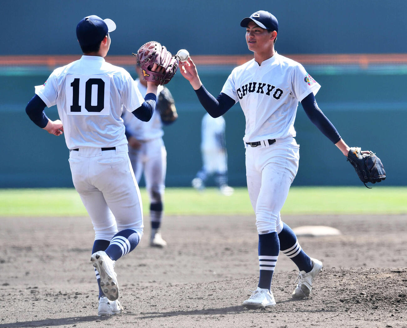 中京大中京対帝京　5回裏、同点に追い付かれて降板となった中京大中京・安藤（右）は2番手の太田に　ボールを渡してベンチへ戻る（撮影・岩下翔太）