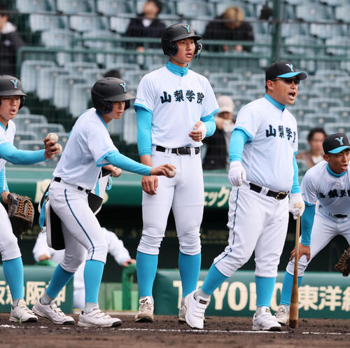 大垣日大対山梨学院　試合前の練習をサポートする山梨学院の菰田（撮影・加藤哉）