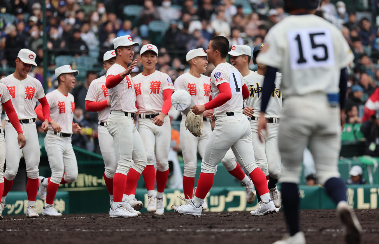 智弁学園対神村学園　完投勝利を収めた智弁学園・杉本（右）はナインとタッチ（撮影・宮崎幸一）