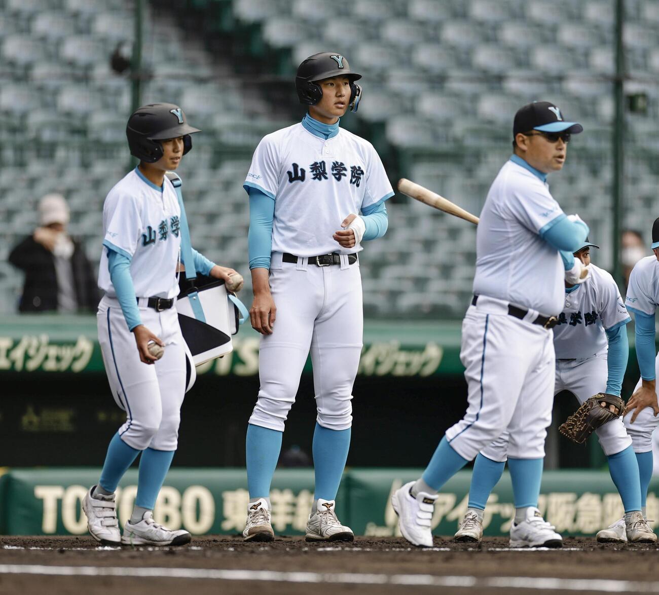 試合前の練習を見守る山梨学院・菰田（中央）＝甲子園（共同）