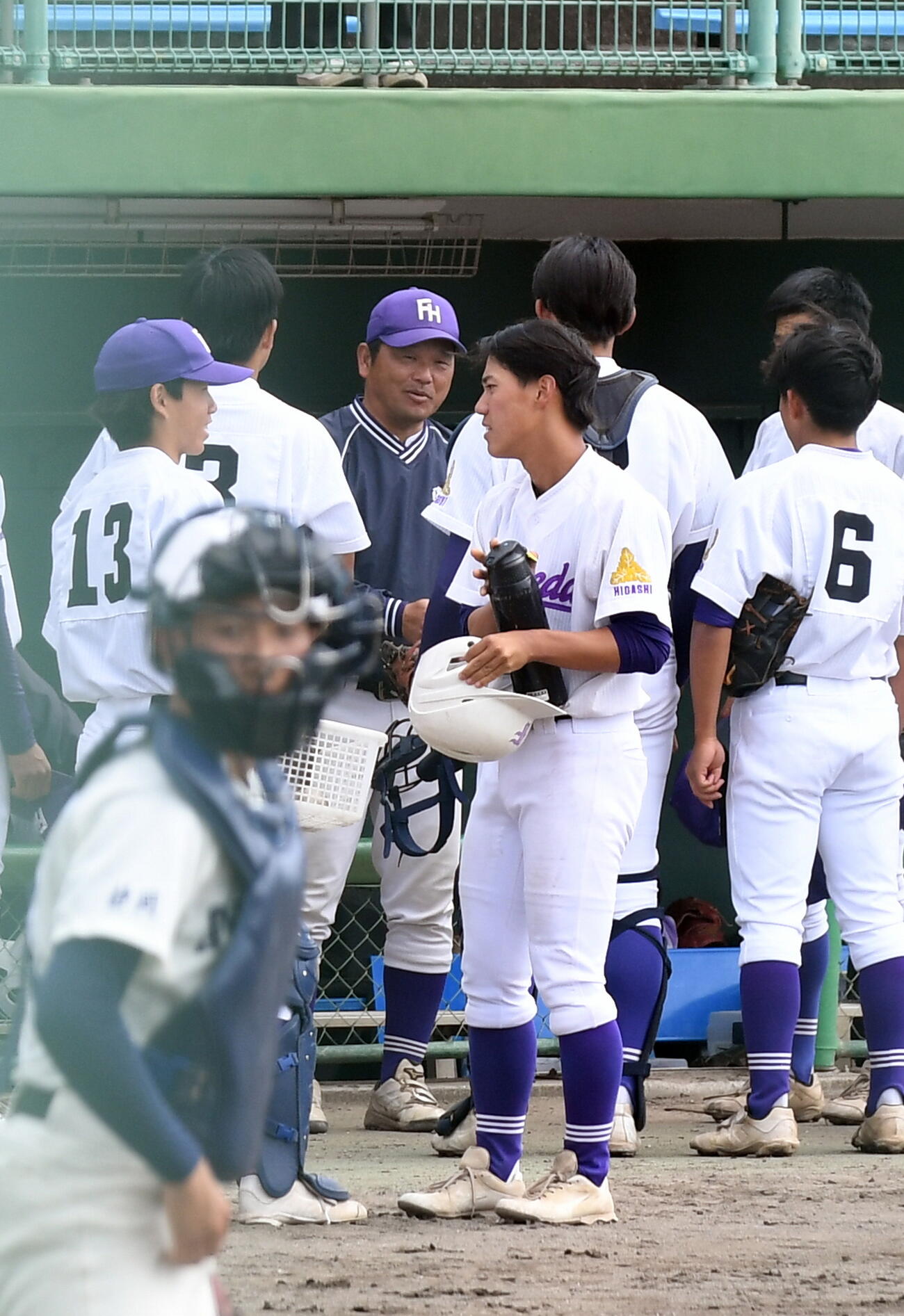 イニング間で選手に話す藤枝東・大石監督（中央奥）