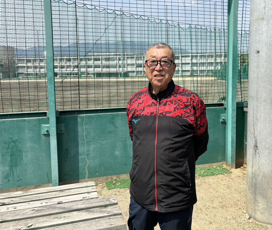 智弁学園の井元部長がグラウンドを背に笑顔を見せる（撮影・林亮佑）