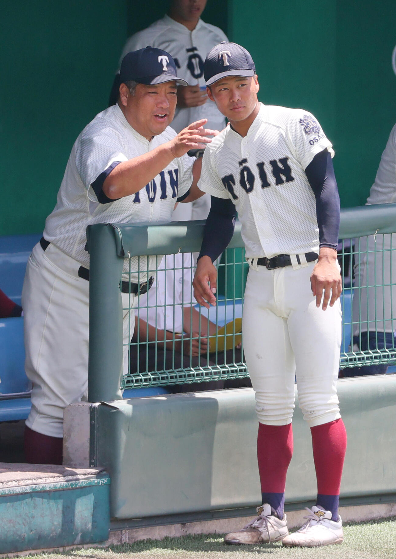 2025年7月、大阪大会決勝　7回裏、大阪桐蔭の西谷浩一監督（左）から指示を受ける中野大虎