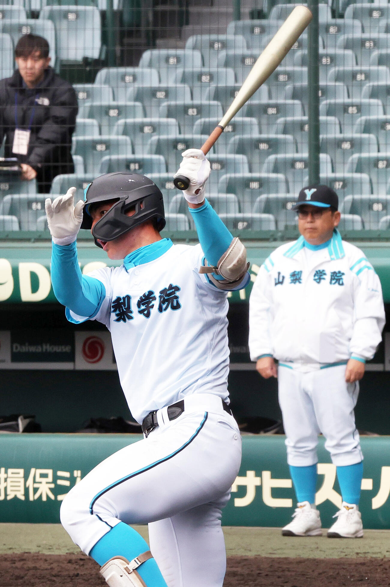 甲子園練習で打撃する山梨学院の菰田。後方右は吉田監督（撮影・上山淳一）