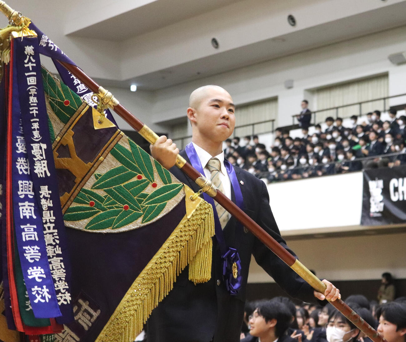 センバツ優勝報告会で優勝旗を手に入場した、大阪桐蔭・主将の黒川（撮影・中島麗）