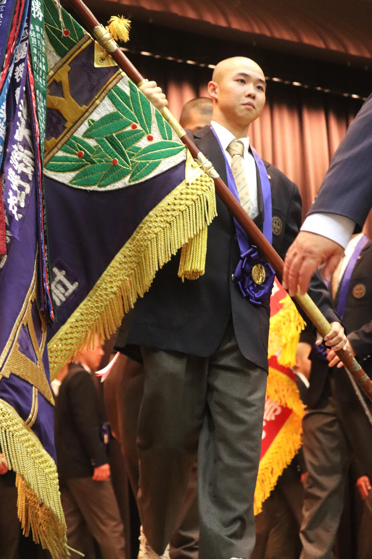 センバツ優勝報告会で優勝旗を手に退場した、大阪桐蔭・主将の黒川（撮影・中島麗）