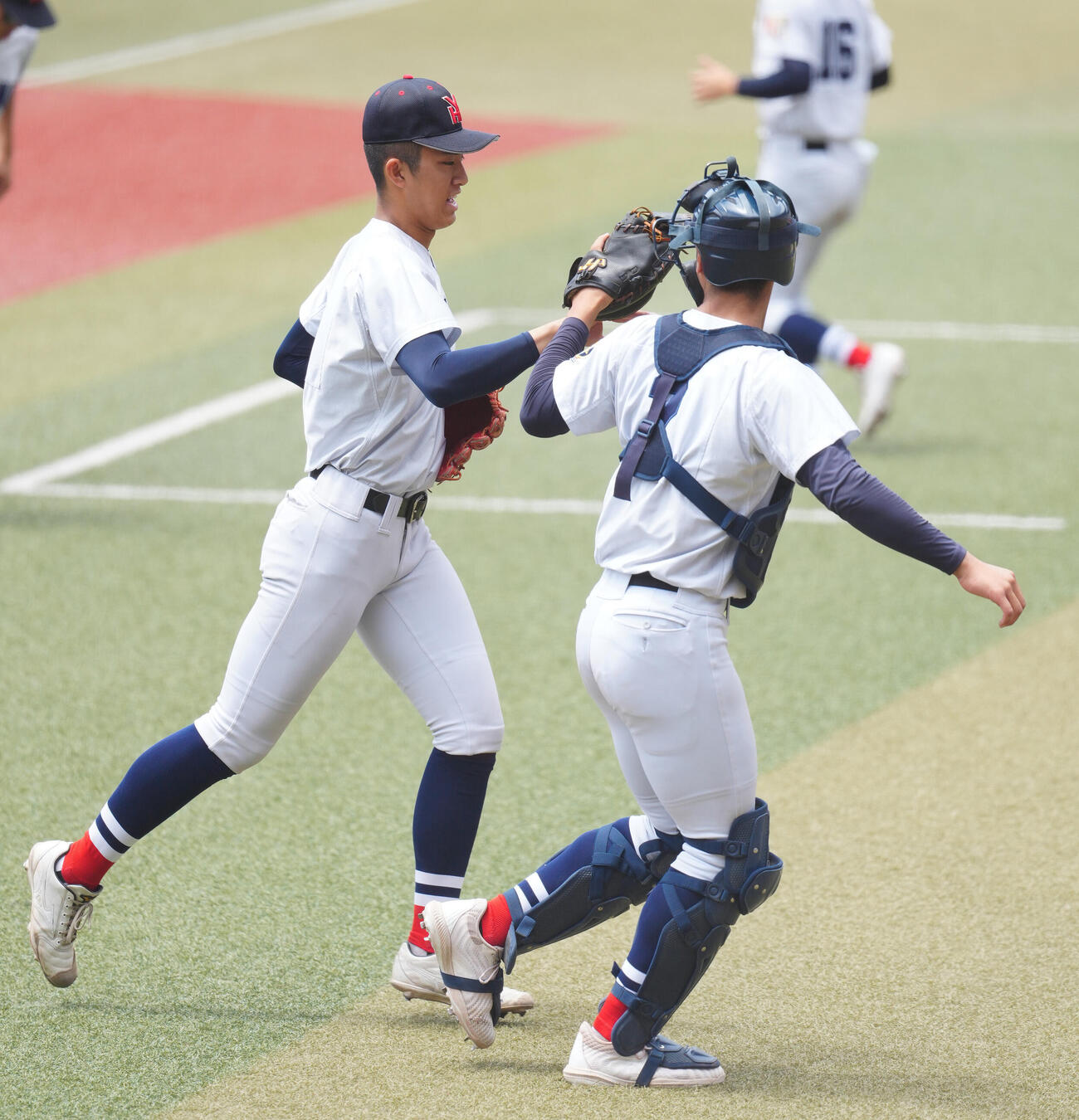 高校野球春季関東大会　準決勝　山梨学院対横浜　7回表を終え、脇山魁音（右）とタッチを交わす横浜・織田翔希（撮影・鈴木みどり）＝2026年5月23日