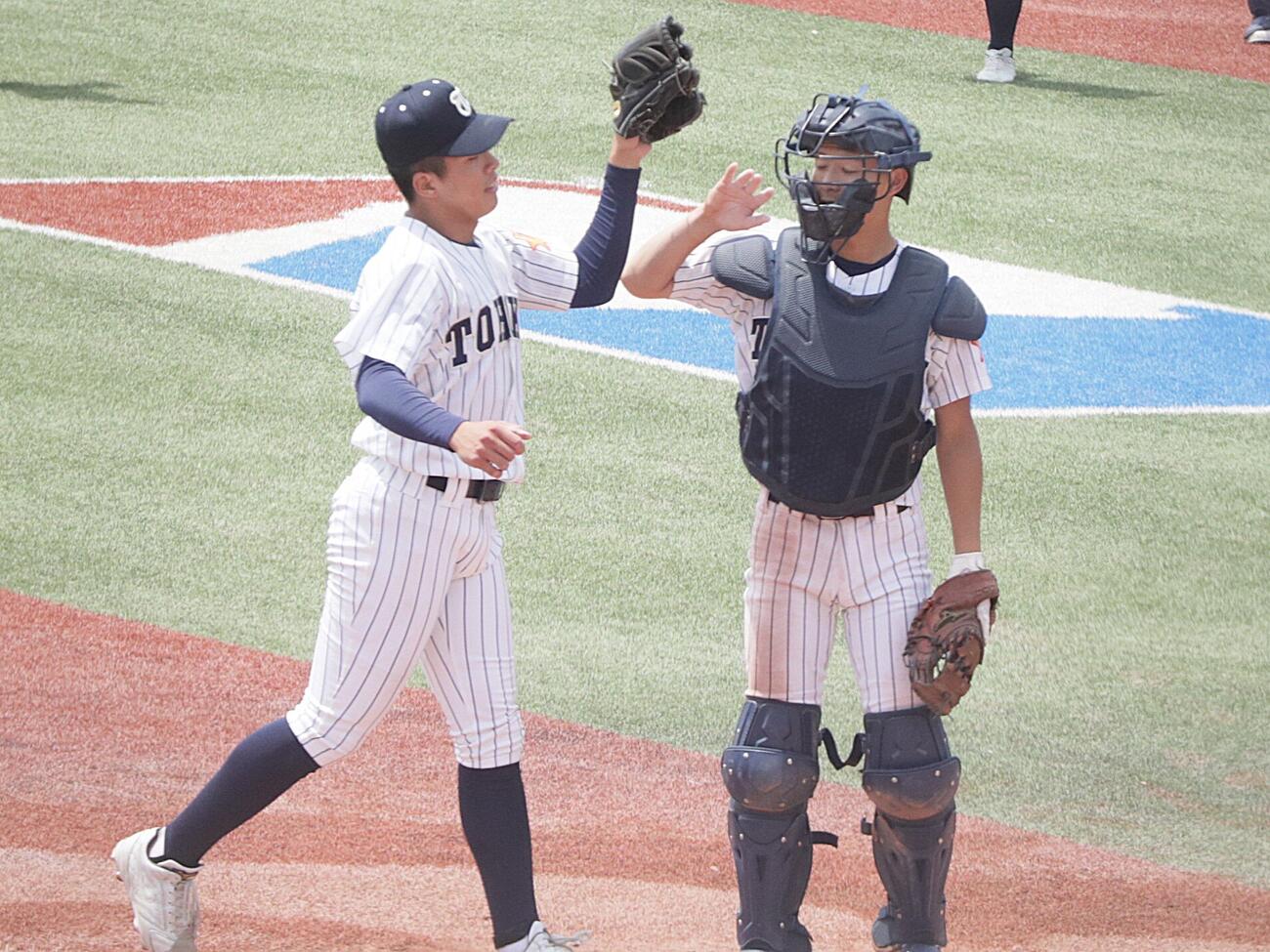 東北学院榴ケ岡対東北　ラストバッターを打ち取りハイタッチする東北・狩野哲平投手（左）と及川陽希捕手（撮影・高橋香奈）