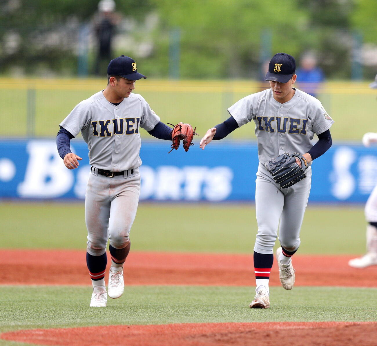東北対仙台育英　優勝し、仲間とタッチする仙台育英・梶井湊斗（右）（撮影・木村有優）