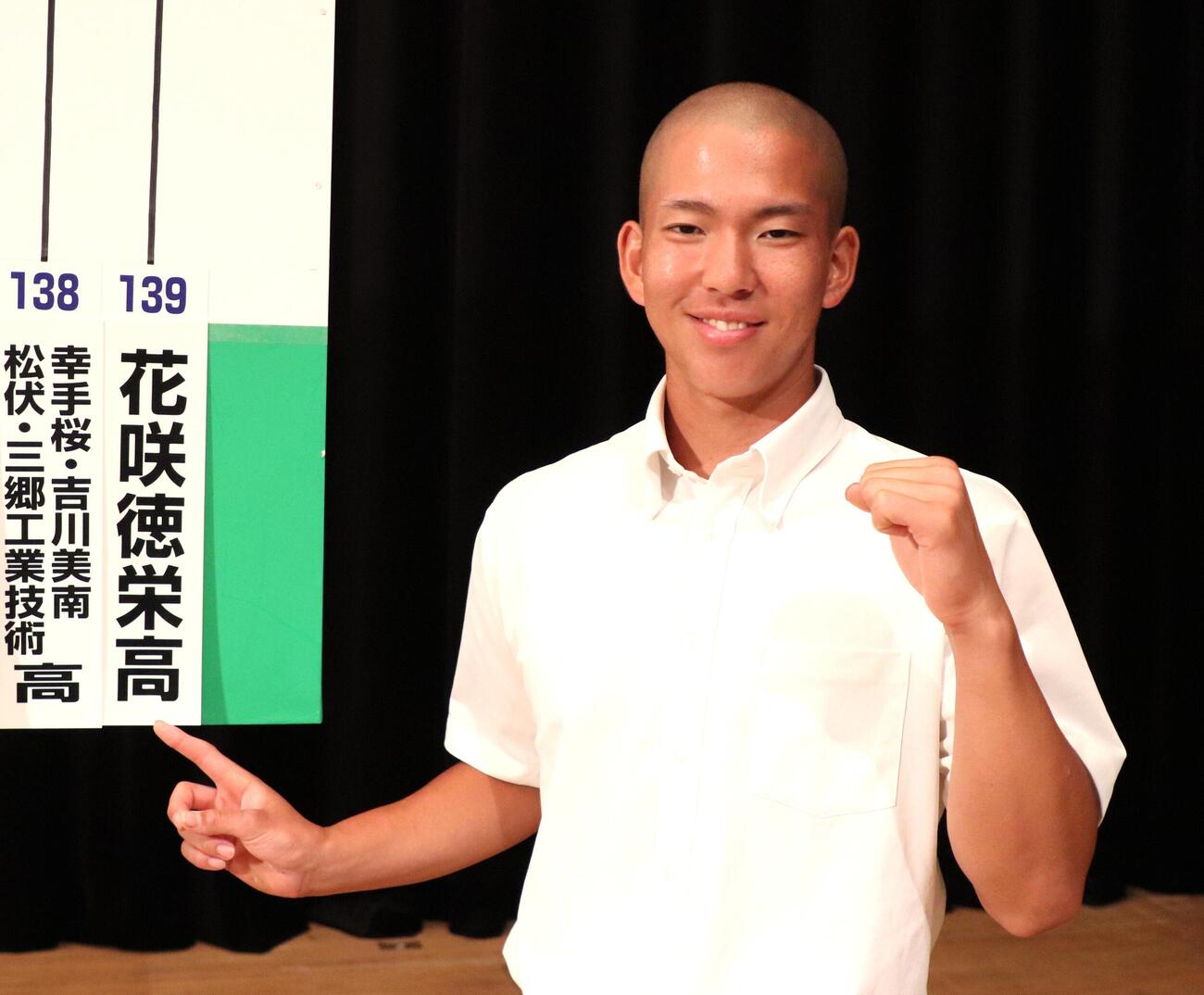 笑顔で自身の高校を指さす花咲徳栄・本田新志（撮影・会田京叶）