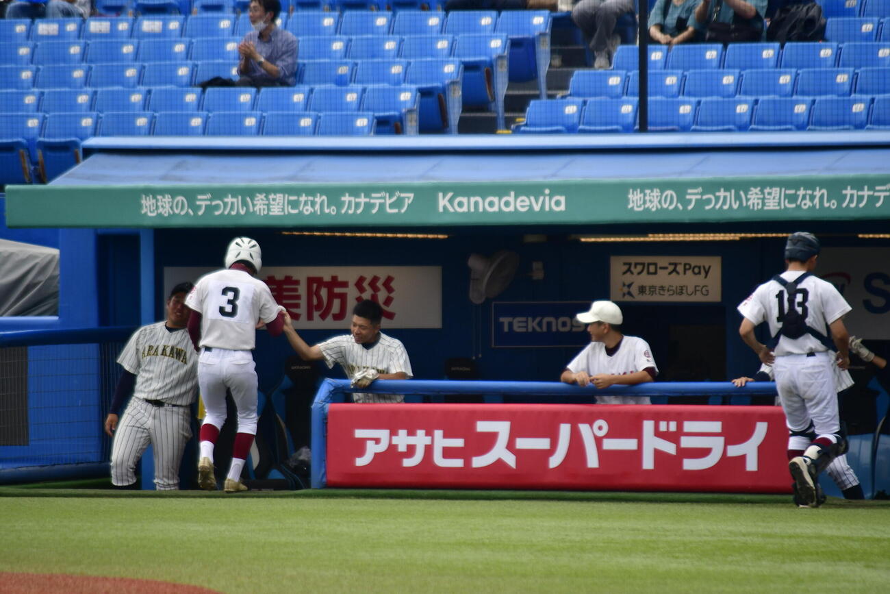 本塁に生還を果たし、ベンチで仲間に出迎えられる大島海洋国際の中山（撮影・平山連）
