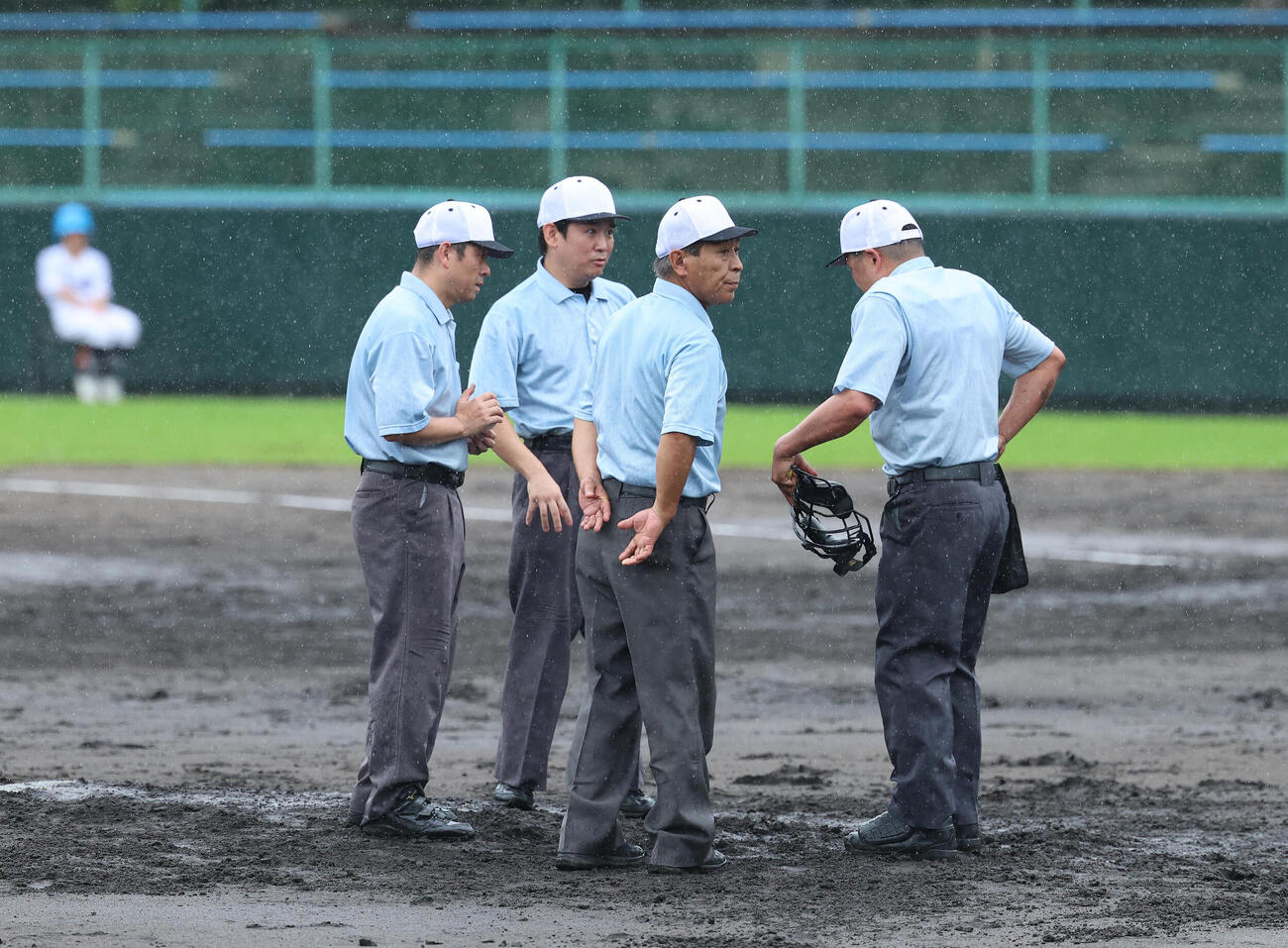 今宮対鳳　4回を終え降雨が強まりマウンドに集まり協議する審判団（撮影・白石智彦）