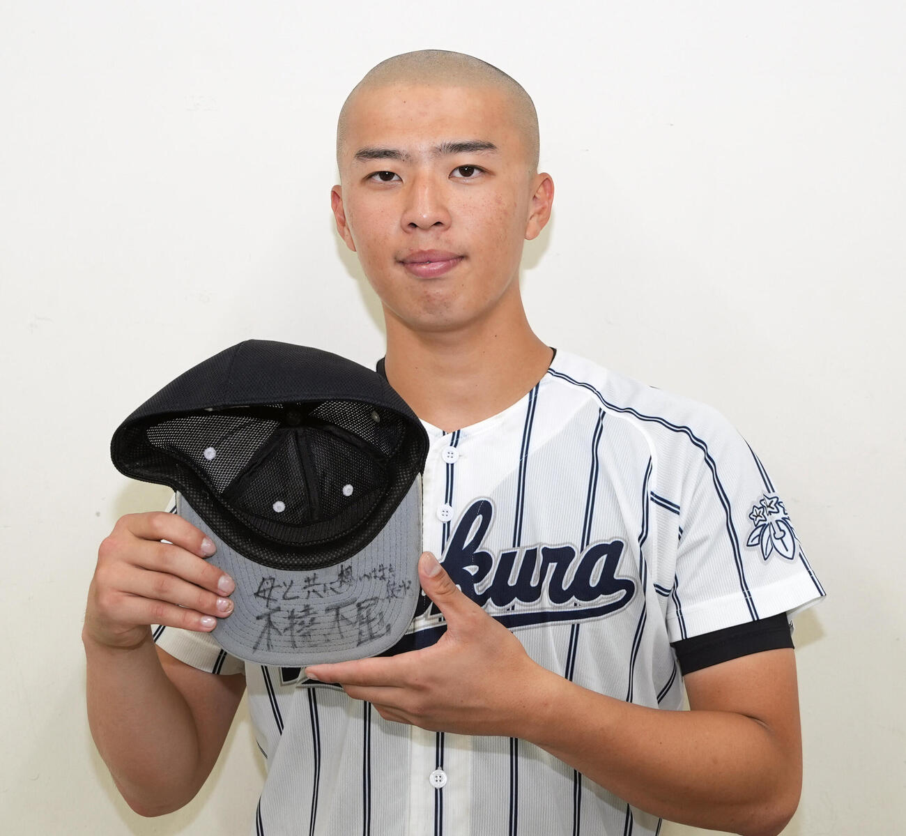 足立学園対岩倉　足立学園に勝利し帽子を手に写真に納まる岩倉・佐藤海翔（撮影・小島史椰）