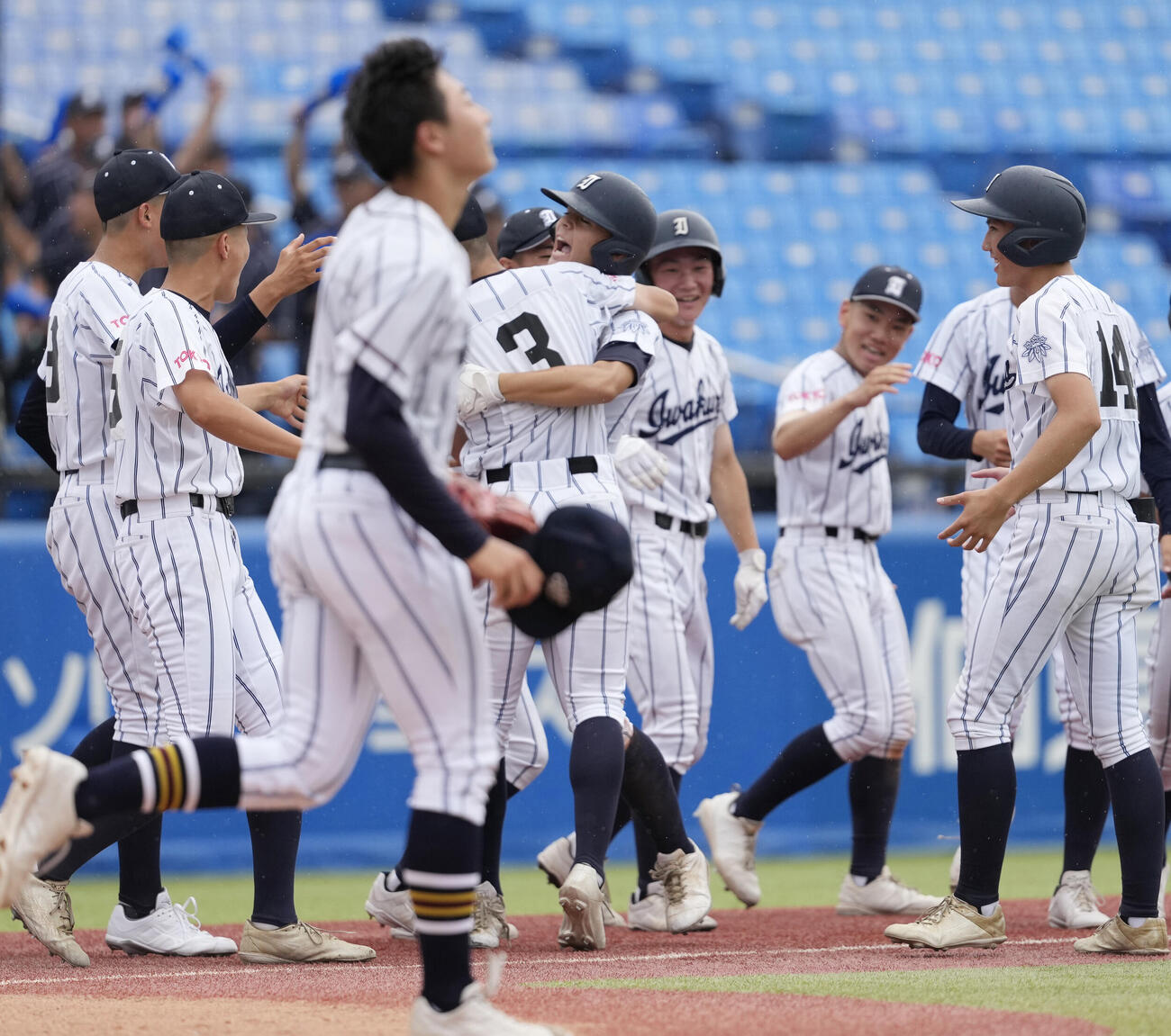 足立学園対岩倉　9回裏岩倉無死一塁、サヨナラ適時二塁打を放ちナインから祝福される庄司トーマス（中央）（撮影・小島史椰）