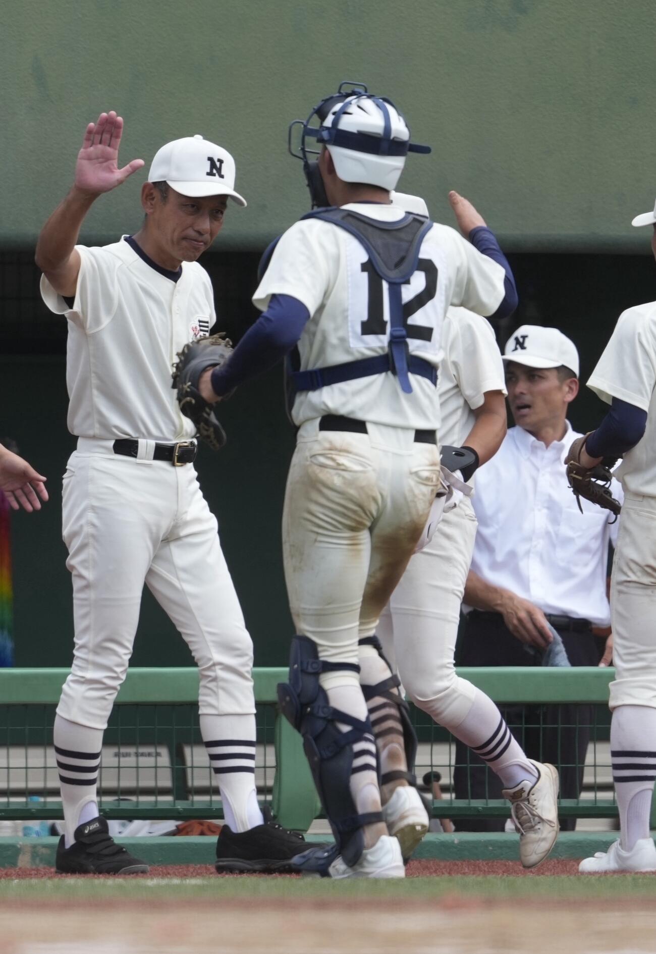 日大三対世田谷学園　6回終了後、選手とタッチを交わす日大三・三木有造監督（左）（撮影・小島史椰）