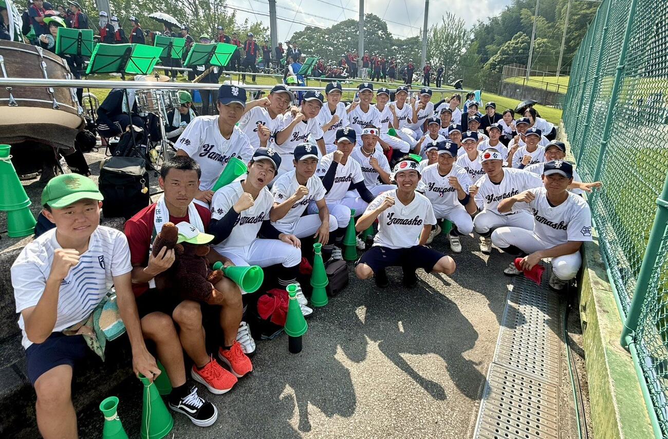 試合前のシートノックのチャント応援で盛り上がった、宇治山田商の部員や、はちまきを巻いた大太鼓担当で硬式野球部OB吉岡裕一郎さん（写真右中央）（撮影・中島麗）